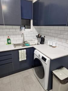 a kitchen with a washing machine and a sink at Pav's Den in Ince-in-Makerfield