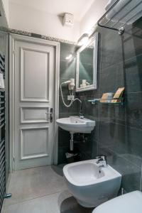 een badkamer met een wastafel, een toilet en een spiegel bij Teresa Rooms & Suites in La Spezia