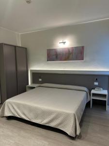 チェントにあるHotel Europaのベッドルーム1室(ベッド1台、壁に照明付)