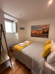 - une chambre avec un lit doté d'oreillers jaunes dans l'établissement Allfado Apartments, à Lisbonne