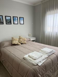 a bedroom with a bed with towels on it at Departamento Rivadavia in Santa Fe +85 photos
