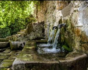 a water fountain in a stone wall at Affitti brevi Donna Rosa in Racalmuto +8 photos