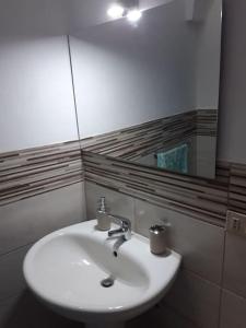 a bathroom with a white sink and a mirror at Affitti brevi Donna Rosa in Racalmuto +8 photos