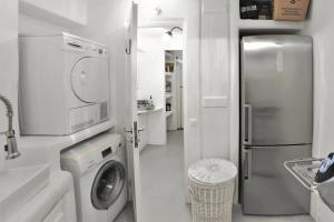a kitchen with a washing machine and a refrigerator at MichaelAngelo Villa in Mikonos