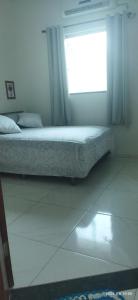 Bett in einem Zimmer mit Fenster in der Unterkunft Apartamento 2 Privado Central in Boa Vista