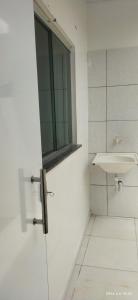 La salle de bains blanche est pourvue d'un lavabo et d'une fenêtre. dans l'établissement Apartamento 2 Privado Central, à Boa Vista