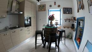 a kitchen with a small table and stools in it at Appartamento Luca e Giulia in San Bernardino