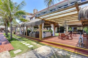 an outdoor deck with tables and chairs and a building at Flat Pietra in Florianópolis