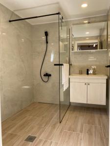 a shower with a glass door in a bathroom at Penthouse in Bogomolje +15 photos