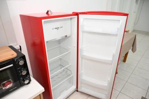 a red refrigerator with its door open next to a microwave at Aurora Studio Apt for Couples & Friends in Heraklio Town