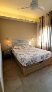 a bedroom with a bed and a ceiling fan at SweetWater Beach - Apartamento turístico en zona puerto in Aguadulce