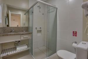 a bathroom with a shower and a toilet and a sink at Flat Pietra in Florianópolis