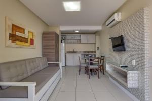 a living room with a couch and a dining room at Flat Pietra in Florianópolis
