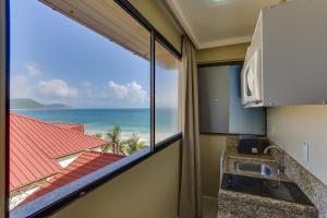 a kitchen with a view of the ocean at Flat Pietra in Florianópolis