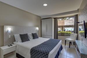 a bedroom with a bed and a large window at Flat Pietra in Florianópolis