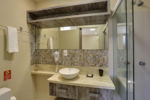 a bathroom with a sink and a mirror at Flat Pietra in Florianópolis