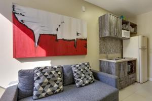 a living room with a couch and a kitchen at Flat Pietra in Florianópolis