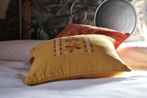 żółtą poduszkę siedzącą na łóżku w obiekcie Le Foyer de Grand-mère w mieście Fénis
