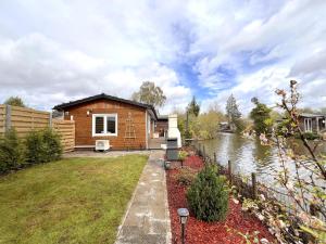 una casa con un río delante de ella en Fonnies Chalet, en Geel