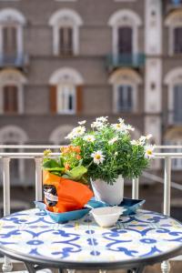 een tafel met bloemen en een tas erop bij Teresa Rooms & Suites in La Spezia
