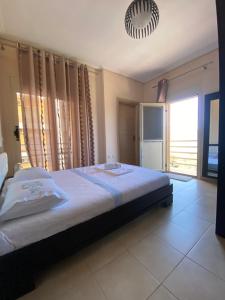 a bedroom with a large bed and a large window at L'odore del mare in Vlorë