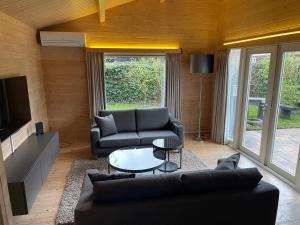 a living room with a couch and a table at Luxe chalet Beek (gem Montferland) bosrijk, rust en privacy in Beek
