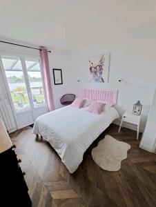 ein Schlafzimmer mit einem großen weißen Bett mit rosa Kissen in der Unterkunft Val'lo'Seine in Duclair