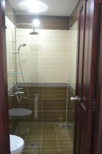 a bathroom with a shower with a toilet and a sink at Khách sạn Minh Nhân in Vung Tau