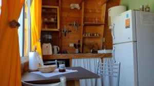 a kitchen with a table and a white refrigerator at La cabaña in San Antonio de Areco