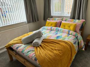 - une chambre dotée d'un lit avec une couverture et des oreillers dans l'établissement Fabulous Bungalow Norwich, à Norwich