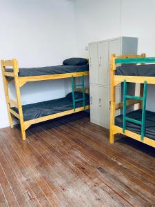 Palta Hostel في مونتيفيديو: غرفة بسريرين بطابقين وكرسيين