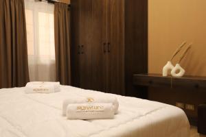a hotel room with two towels on a bed at Signature Stays: Modern Chic Apt in Cairo