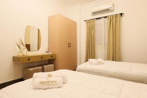 a hotel room with two beds and a mirror at Signature Stays: Modern Chic Apt in Cairo +18 photos