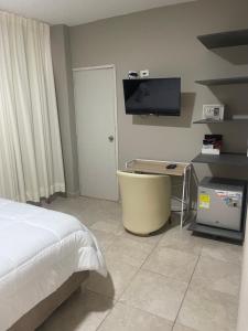 Dormitorio con cama, escritorio y TV en Abel Boutique House, en Cartagena de Indias