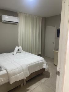 1 dormitorio con cama blanca y baño en Abel Boutique House, en Cartagena de Indias