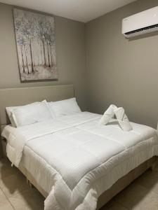 ein weißes Bett in einem Schlafzimmer mit einem Gemälde an der Wand in der Unterkunft Abel Boutique House in Cartagena de Indias