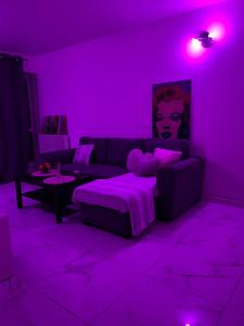 a purple living room with a couch and a table at Appartement proche de La Défense in Puteaux