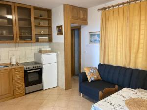 una pequeña cocina con un sofá azul en una habitación en Apartments Deranja, en Dubrovnik