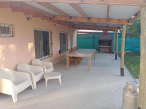 un patio con mesa, sillas y chimenea en La quinta de Lucas en Santa Rosa