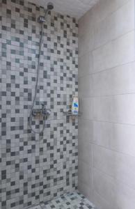 y baño con ducha y pared de azulejos. en Sergios Apartments 4, en Alexandroupoli