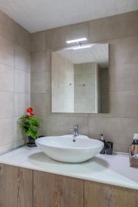 y baño con lavabo blanco y espejo. en Sergios Apartments 4, en Alexandroupoli