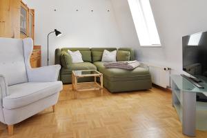 ein Wohnzimmer mit einer grünen Couch und einem Stuhl in der Unterkunft Hamburg App. 08 in Ahlbeck