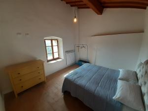 a bedroom with a bed and a dresser and a window at Castello Montefiridolfi in Montefiridolfi
