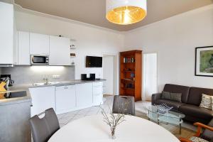 eine Küche und ein Wohnzimmer mit einer Couch und einem Tisch in der Unterkunft Villa Schering App. EG links in Heringsdorf