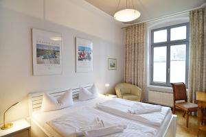 ein Schlafzimmer mit einem großen weißen Bett mit weißen Kissen in der Unterkunft Villa Schering App. EG links in Heringsdorf