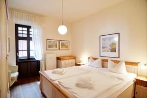 - une chambre avec un grand lit et des draps blancs dans l'établissement Strandklause-App-04, à Heringsdorf