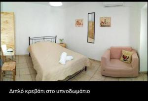 a bedroom with a bed and a chair in it at Το σπίτι του Νίκου και της Κατερίνας in Andros