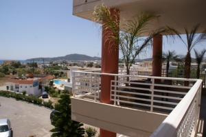 un balcone di un edificio con palme e un parcheggio di Faliraki Dream Apartments & Studios a Calitea (Kallithea)