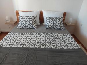 uma cama com almofadas pretas e brancas em Apartman Mia Vir em Vir