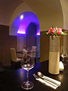 a table with a wine glass and a vase with flowers at Hotel U Kříže in Prague